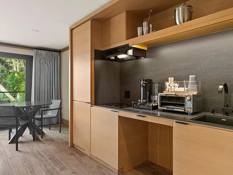 Kitchenette equipped with a ninja blender, garbage disposal, nespresso bar station, toasters oven, microwave, flatware, dinnerware, coffee cups, and bottle opener