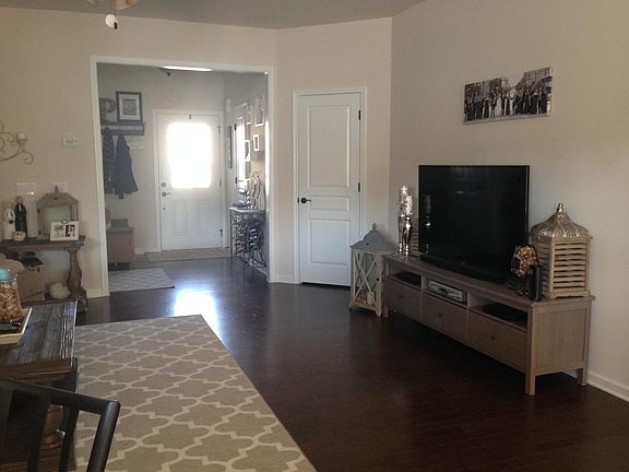 Main floor living room and front door entrance, half bath on the right next to the front door and hall closet next to the TV