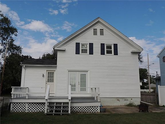 Exterior back with FRESHLY PAINTED EXTERIOR AND DECK with an additional patio for a firepit.