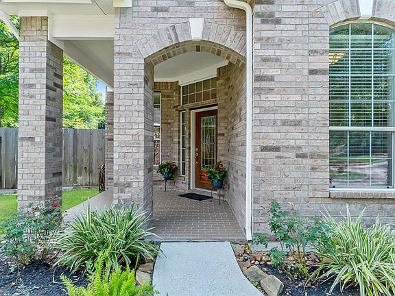 This inviting front porch with brick pavers leads you inside through the beautiful front door with intricate glass design.