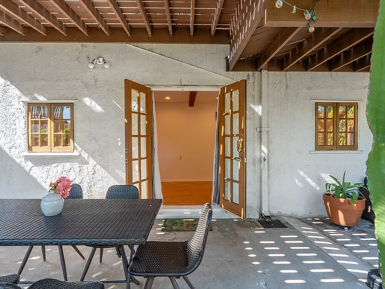 French doors from private covered patio opening to back studio