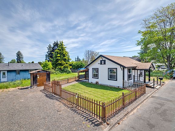 large parking area, picket fenced yard, and attractive home