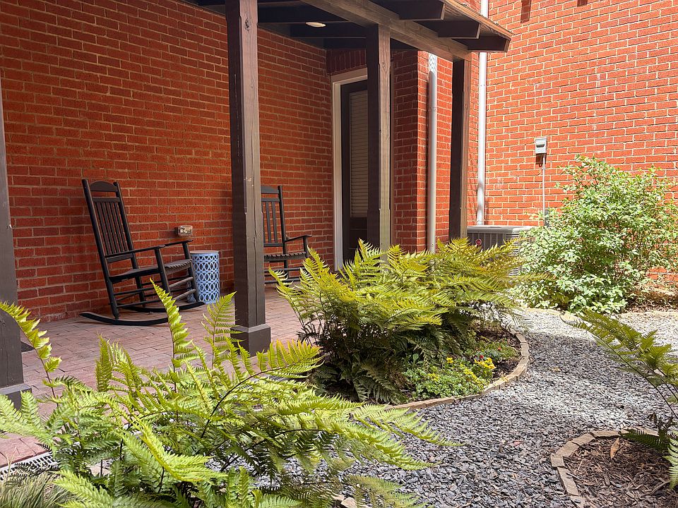 The private courtyard features rocking chairs under a covered porch.