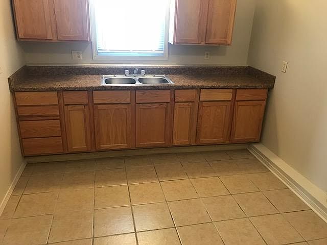 large kitchen with plenty  of cabinets/tiled floor & SS sink