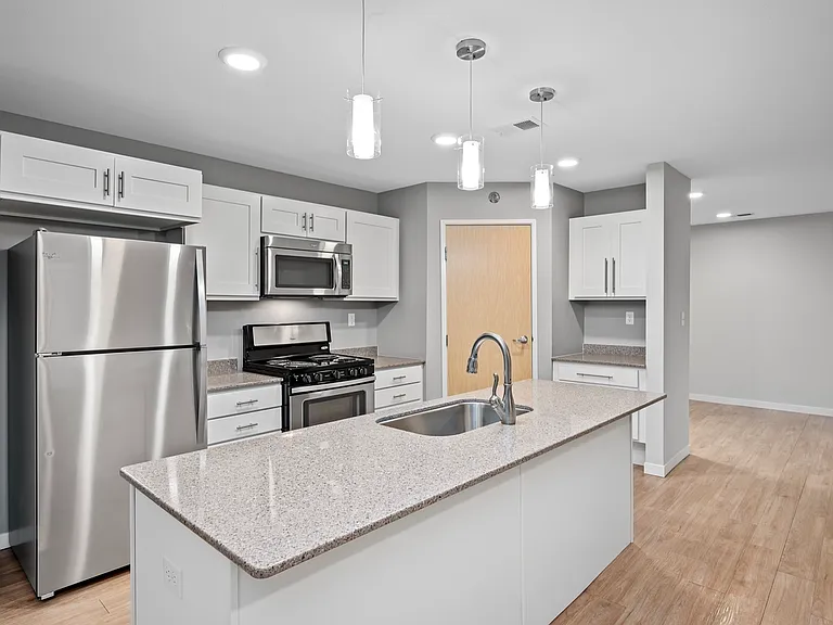 Modern kitchen with sleek stainless steel appliances, granite countertops, and elegant pendant lighting. Modern kitchen with sleek stainless steel appliances, granite countertops, and elegant pendant lighting.