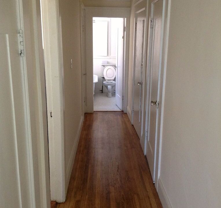 hallway within apartment leading into kitchen, bathroom, and