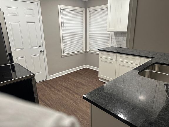 New laminate flooring in kitchen with a door to the one car garage