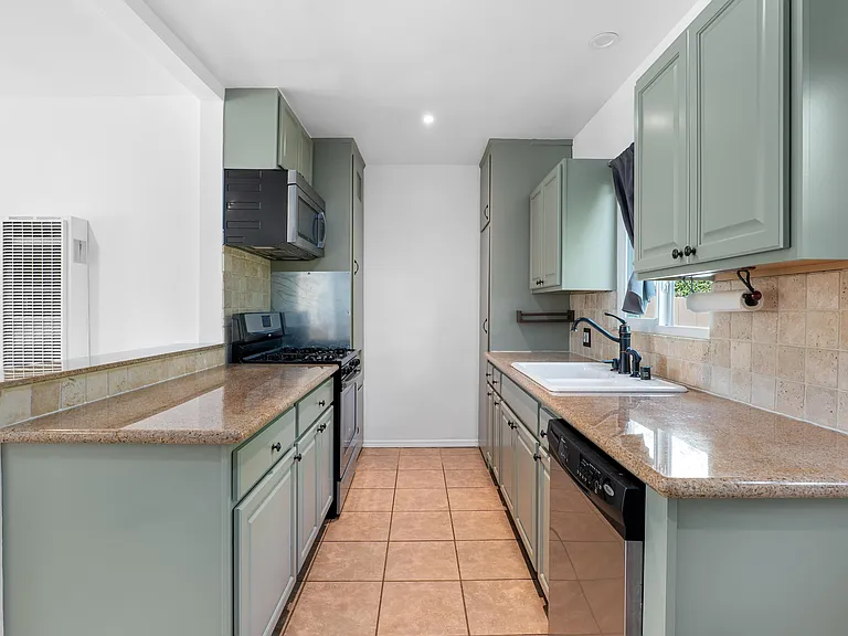 Kitchen features stainless steel range, refrigerator, and over the stove microwave.