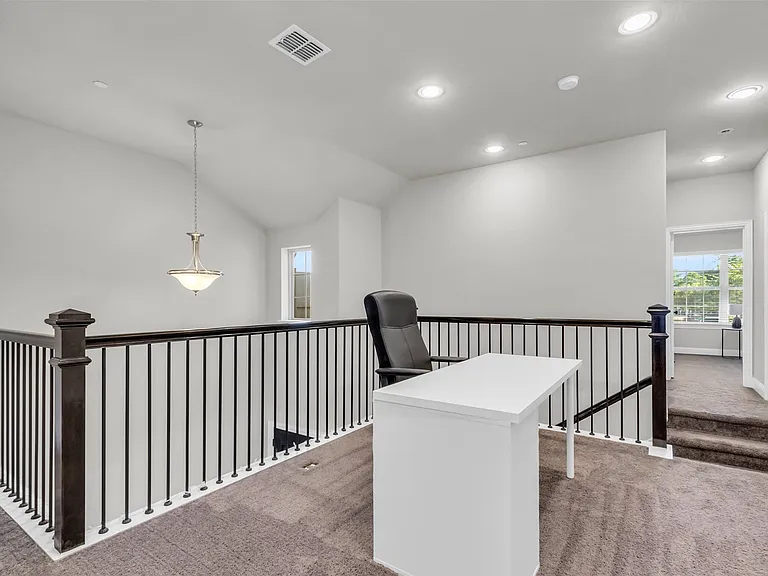 Open loft area featuring a wrought iron and wood railing, recessed lighting, vaulted ceiling, and carpeted flooring