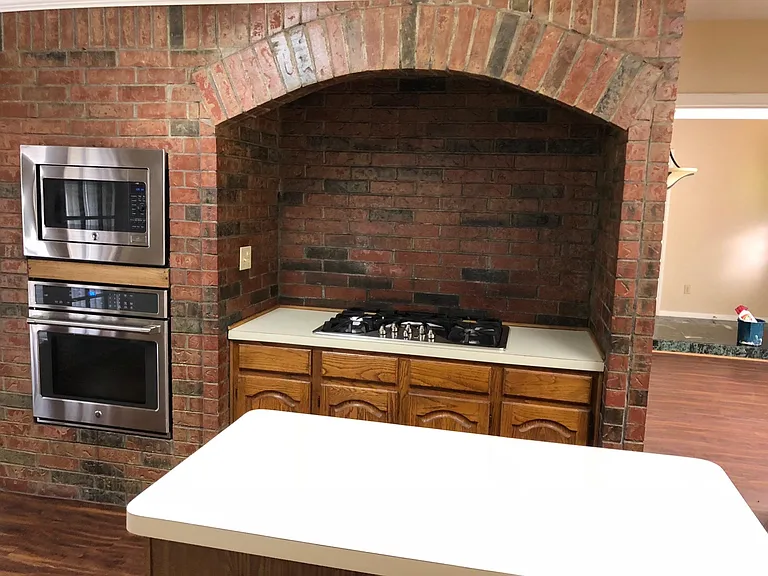 Stove top and kitchen island. You can also see the entrance to the kitchen from the dining room
