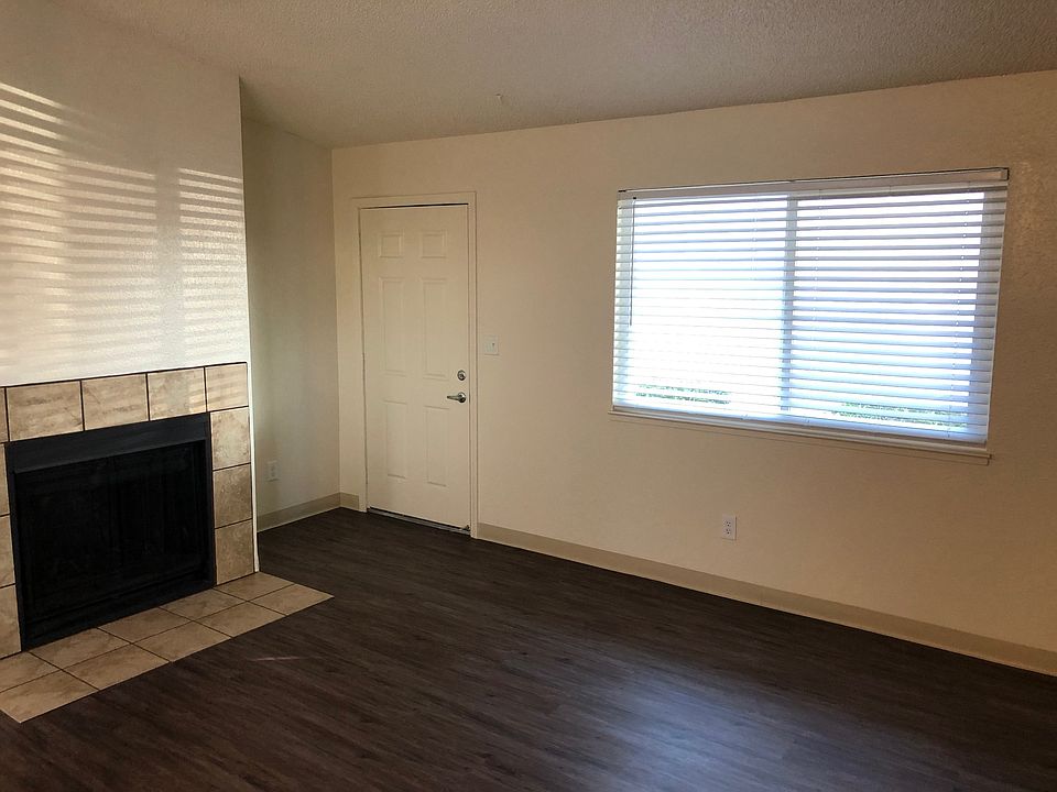 Living room with fresh paint, cordless blinds, vinyl plank flooring and wood burning fireplace