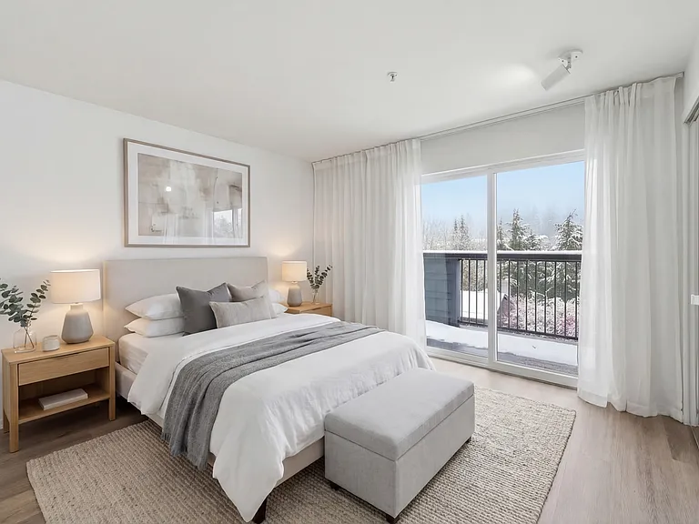 Primary bedroom with balcony access and spacious closets.
