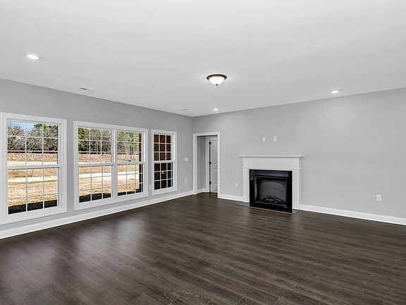 The open concept Claremont plan is filled with natural light and showcases an electric fireplace. En
