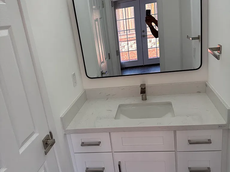 New bathroom with vanity, brushed nickel knobs, large mirror and new sink