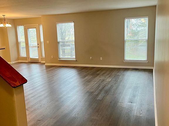 Light-filled floor living room opens to the kitchen and features new flooring and fresh paint