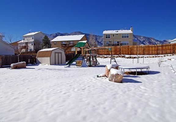 Back of home with playset, trampoline and storage shed included!