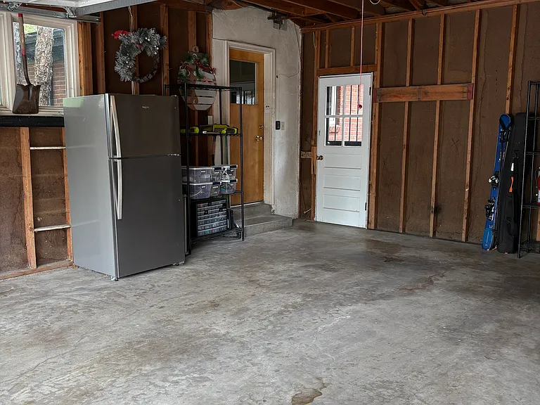 Garage with an extra refrigerator and entrance to the house