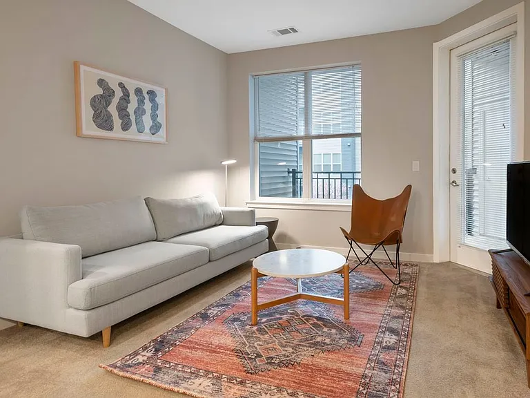 Furnished+ apartment homes come outfitted with a sofa, side chair, side table, coffee table, TV stand and 50" Television (Representative Image exact items and style of furnishings may vary)