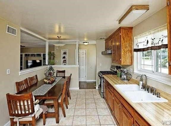 Kitchen w/dining area, tile flooring, and oak cabinetry.