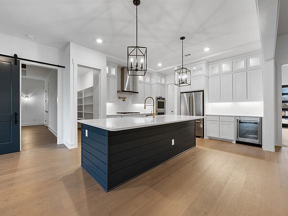 The kitchen has gorgeous white cabinetry with black hardware.