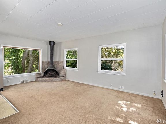 Large living room with fireplace.  Large bay window looks out over Thornton Creek.