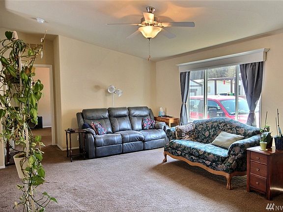 A welcoming living room that boasts a ceiling fan!