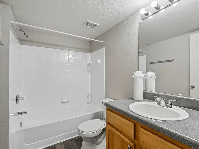 En-suite bathroom with full bathtub and shower combination, large vanity, and mirror in a 3-bedroom, 2-bath apartment at Gregory Cove in Jacksonville, FL.