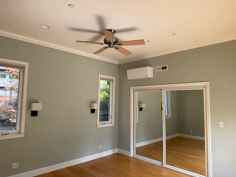 Primary bedroom with 10ft ceilings, ensuite bathroom and AC.