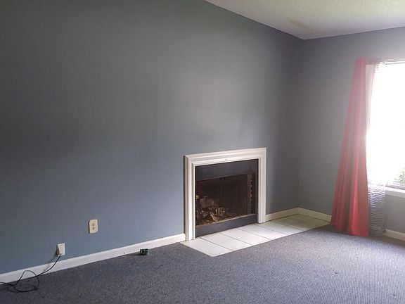 Living room with vaulted ceiling and decorative fireplace