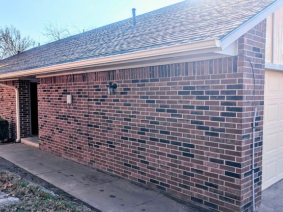 View of walkway to front door and garage door