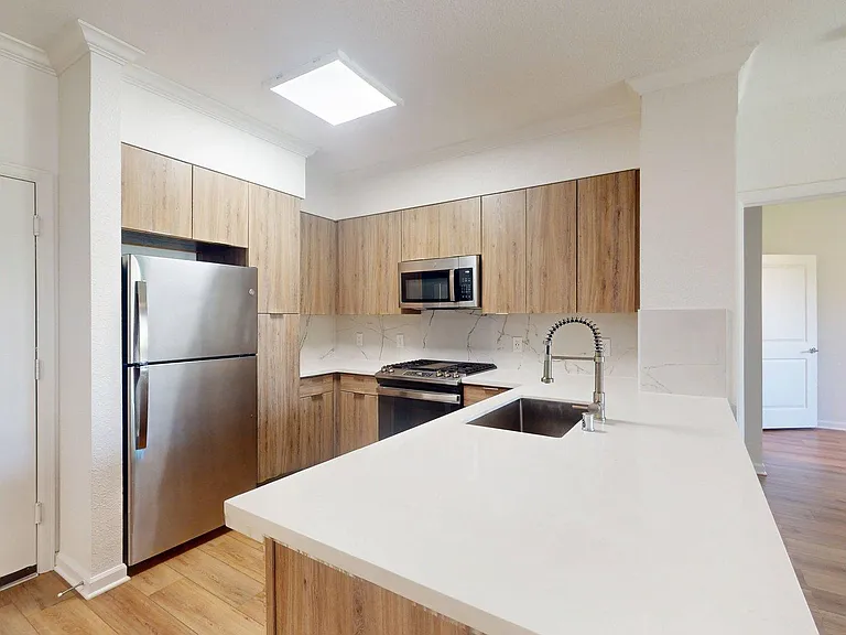 Apartment Kitchen with white countertops and wood-style flooring
