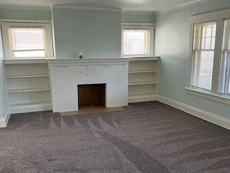 Living room fireplace (none working) with beautiful bookshelves on both sides
