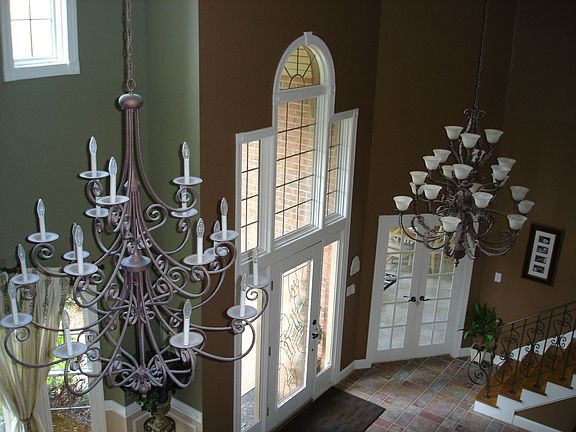dramatic two story foyer and dining area with custom made iron chandaliers