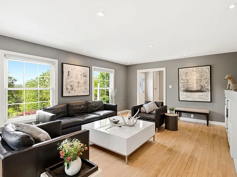 Main living room with tons of windows, built in shelving, and cozy fireplace.