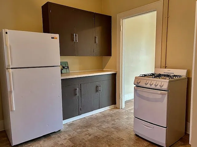 Full sized refrigerator and plenty of kitchen cabinet space for storage
