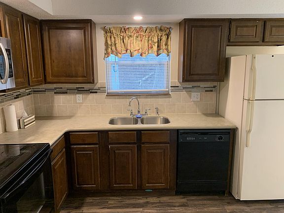 Kitchen view from hallway/living room, additional cabinets to left of stove