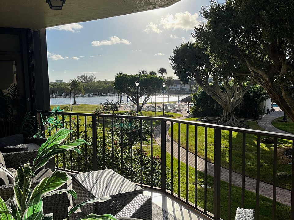 Intracoastal and pool view from large balcony with 2 large chairs, loveseat, coffee table.