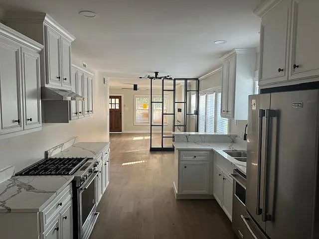 View of Kitchen, dining room and living room while standing an entry of pantry.