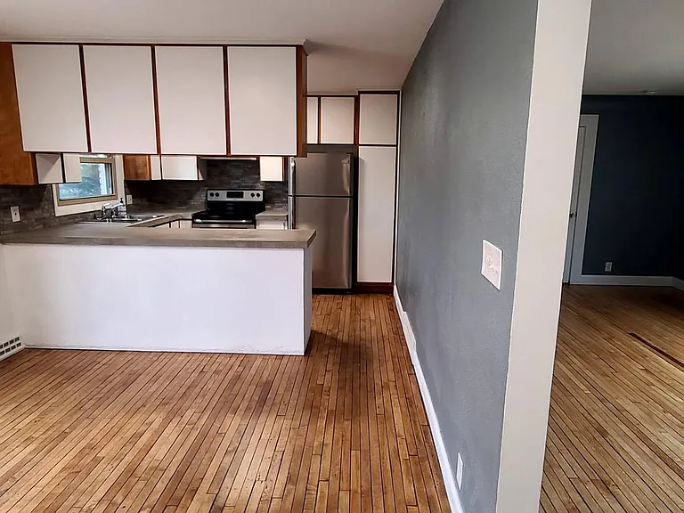 Kitchen and dining area (private deck access) on left side and Living room on right side.