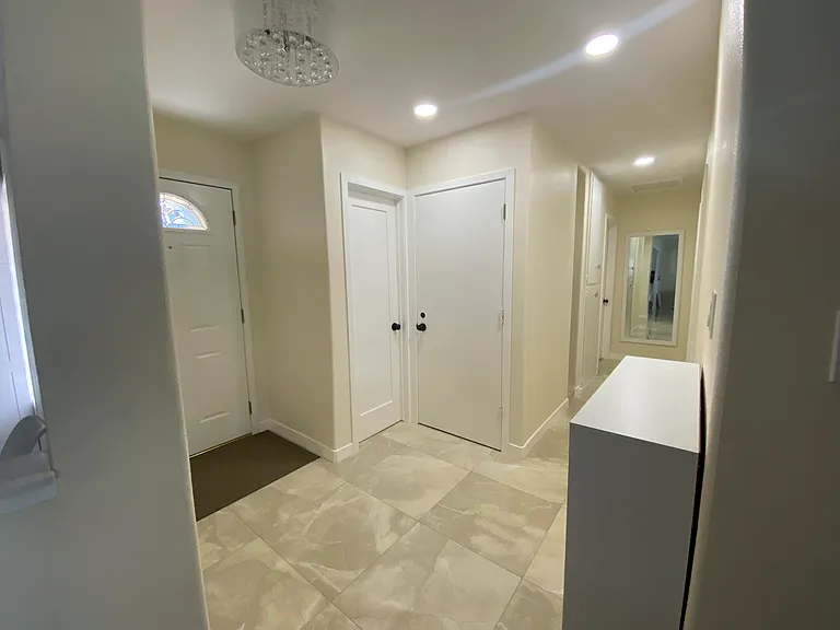 entry way showing shared full bath and laundry closet