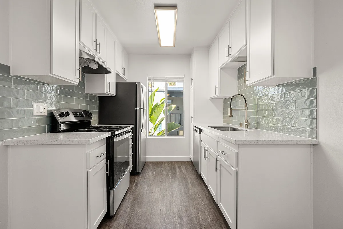 Cook, dine, and gather in a stylish kitchen space. - Palms Apartments
