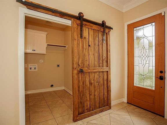 The rustic barn door cleverly disguises the laundry/mud room off the entrance...
