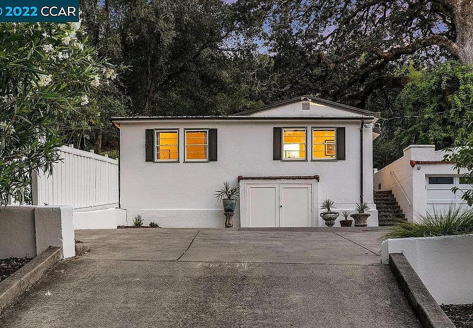 Front view of cottage with living room through left window and kitchen through right window