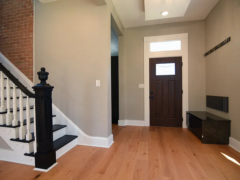 Uncommon, gorgeous entryway Showcasing, indirect lighting assembly in dropped ceiling with convenient coat hanger, bench, and storage.