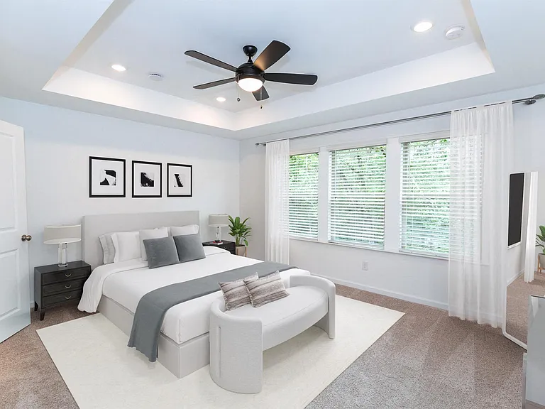 Primary bedroom with king size bed and large window.