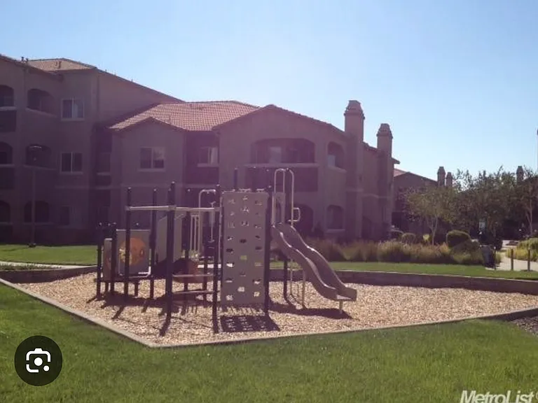 Play area in a parklike setting for the kids located next to the gated pool area.