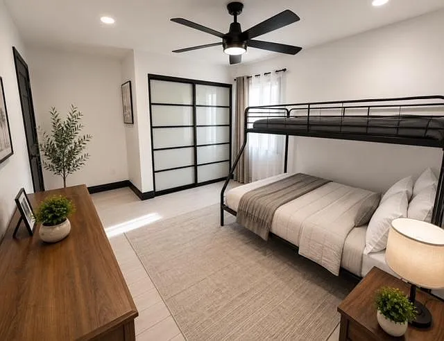 Well-appointed bedroom with a bunk bed setup, ceiling fan, sliding closet doors, and a large area rug for comfort.