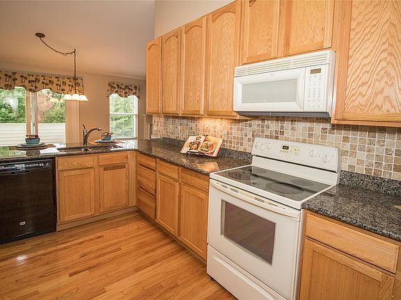 Kitchen offers hardwood flooring, granite, tile back-splash, 42 inch cabinets and a pantry.