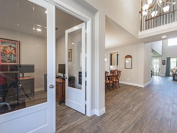 FRONT HALLWAY - To the left is a study with beveled glass French doors. To the right is the private guest bedroom suite. Durable 'weathered' gray tile plank flooring is featured throughout the 1st floor.