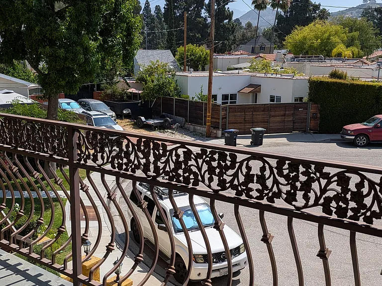 Private balcony with neighborhood and hillside views.